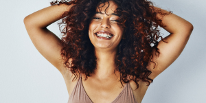 Cortes para cabelo cacheado ideias. Foto mulher negra sorrindo com corte swag nos cabelos