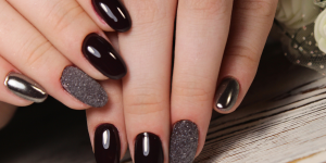 Unhas decoradas com preto. Foto mão com unha colorida de preto e filha única com brilho