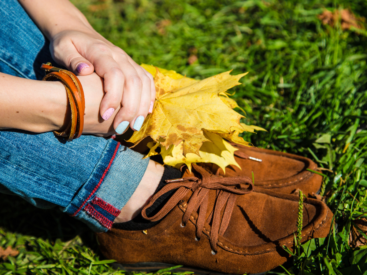 Melhores sapatos para usar nos dias de frio. Foto traz um mocassin marrom sobre a grama