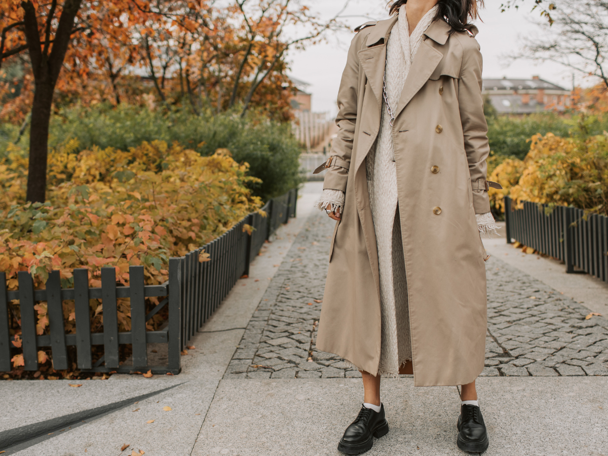 Trench Coat Feminino. Foto mostra uma mulher com o casaco comprido de cor bege