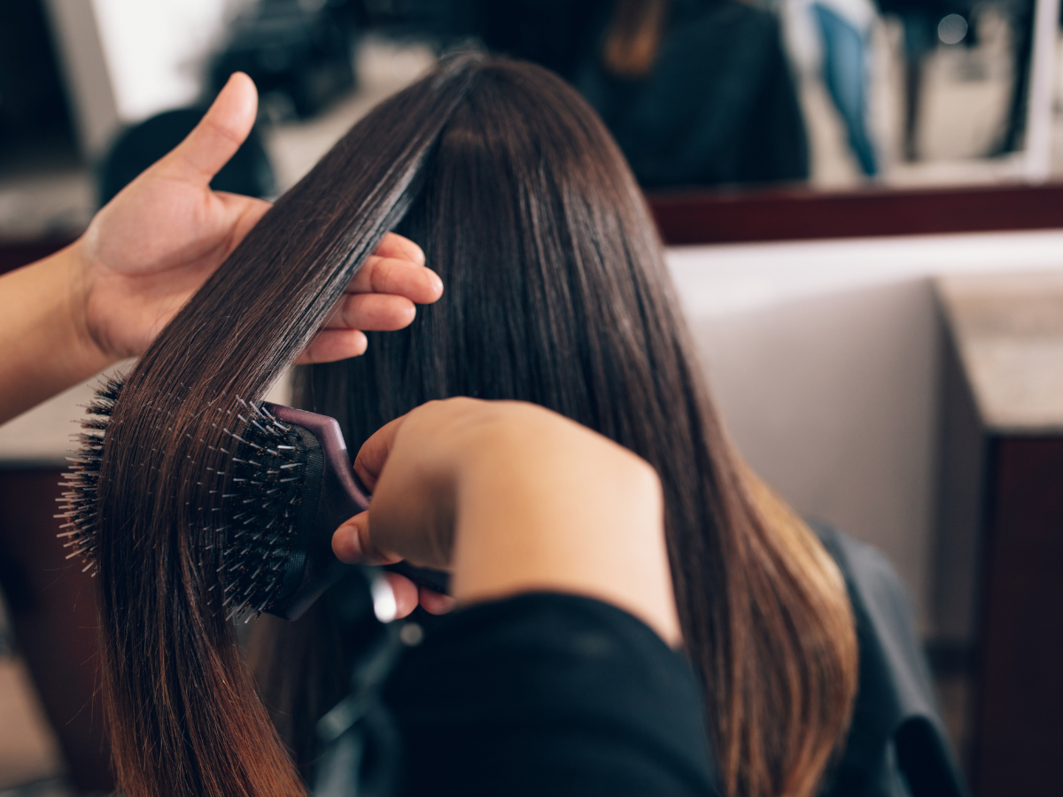 Penteados para cabelos lisos; Foto mostra cabelo liso de cor preta sendo penteado.