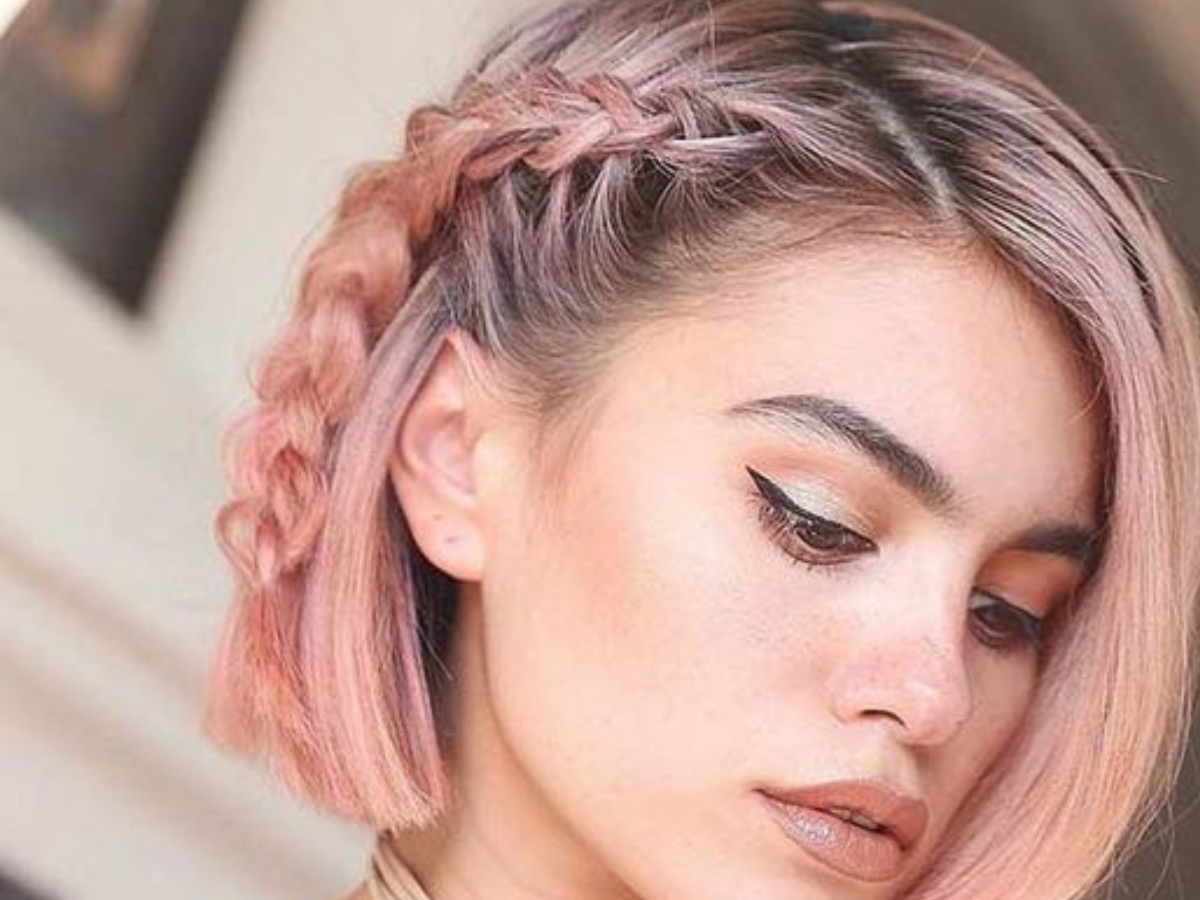 penteados fáceis com cabelo curto. Foto traz mulher de cabelo curto, rosa e com trança na lateral