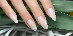 Unhas delicada inspirações. Foto mostra unha transparente com desenhos listrados em branco