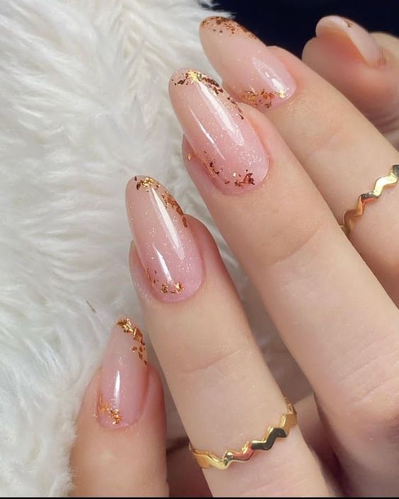 unhas delicadas inspirações. Foto traz unha com detalhes dourados e glitter transparente.