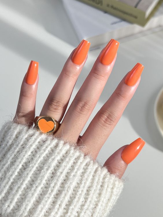 Unha de cor laranja estilo coral. Ela está entre as Unhas para Verão 2024