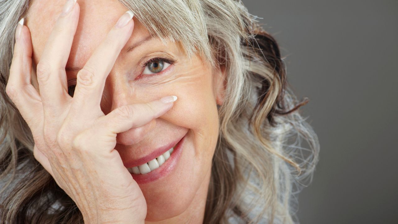 mulher madura com cabelo grisalho sorrindo