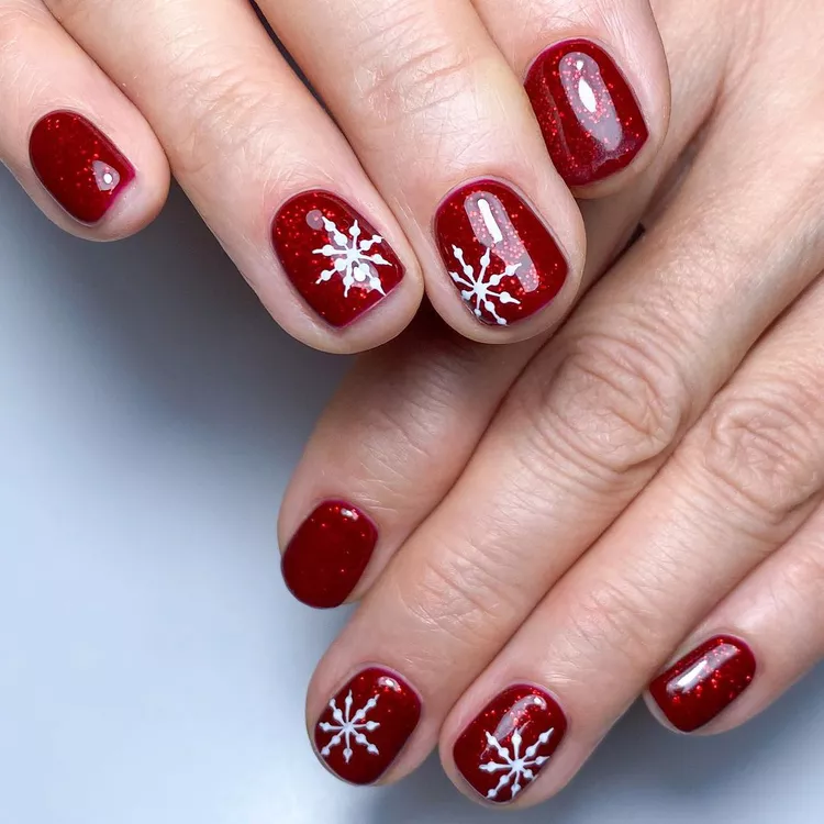 Unhas vermelha glitter com desenho de floco de neve