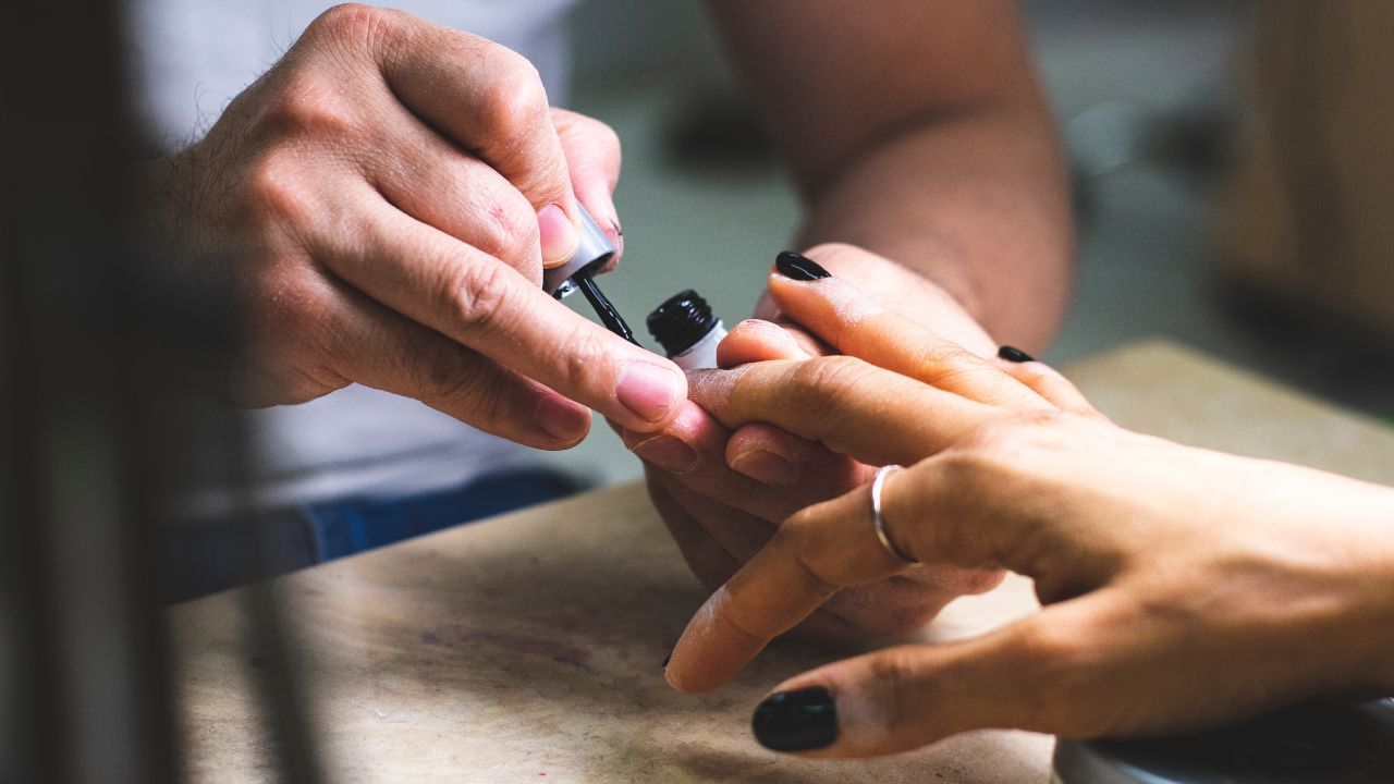 mulher fazendo as unhas de preto