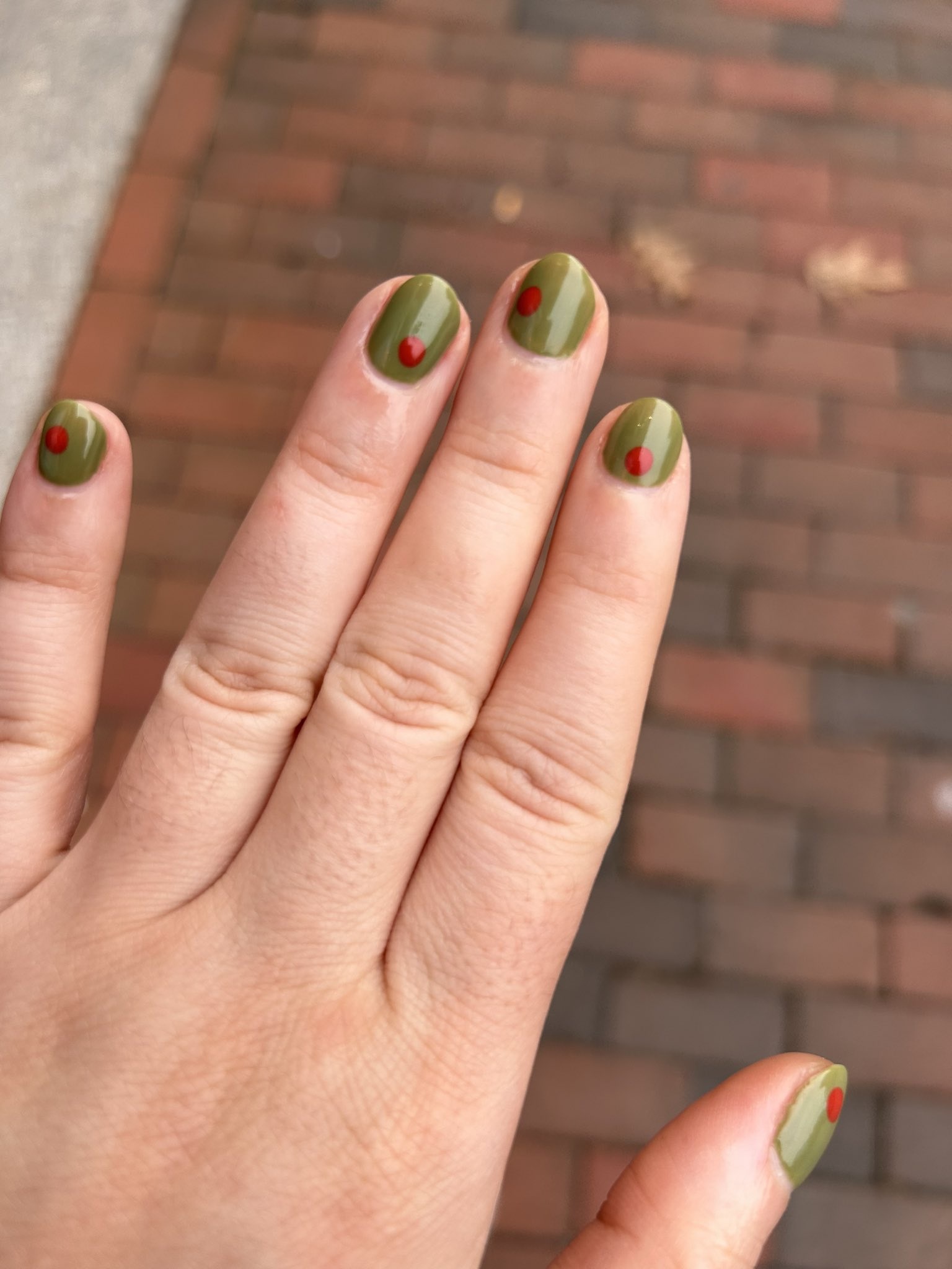 unhas em verde-oliva e pontos vermelhos para representar azeitona